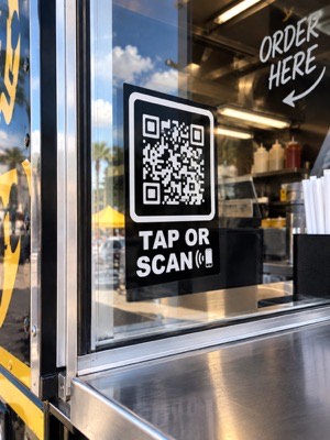 The tap-or-scan sign stuck to a window